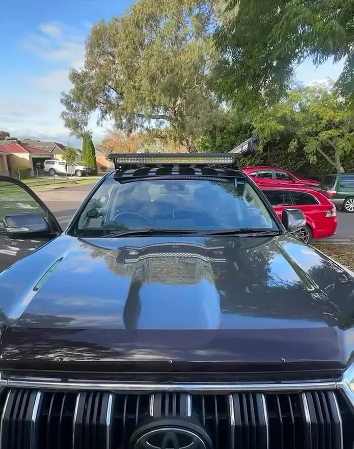 Prado with a light bar across the front of the roof rack